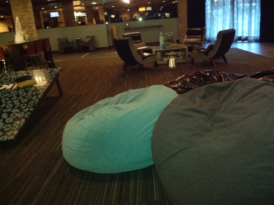 Bean bags and other furniture in the living room area, with one of the oversized bags games nearby at gold spike social club