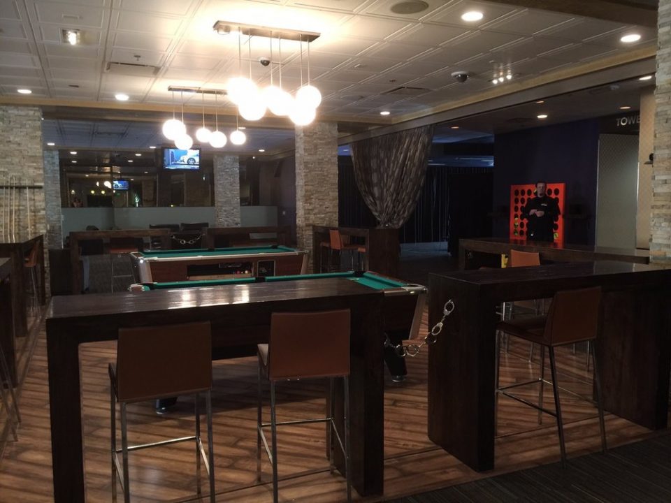 One of the social areas centered on the pool tables, with a large connect four in the background at gold spike social club